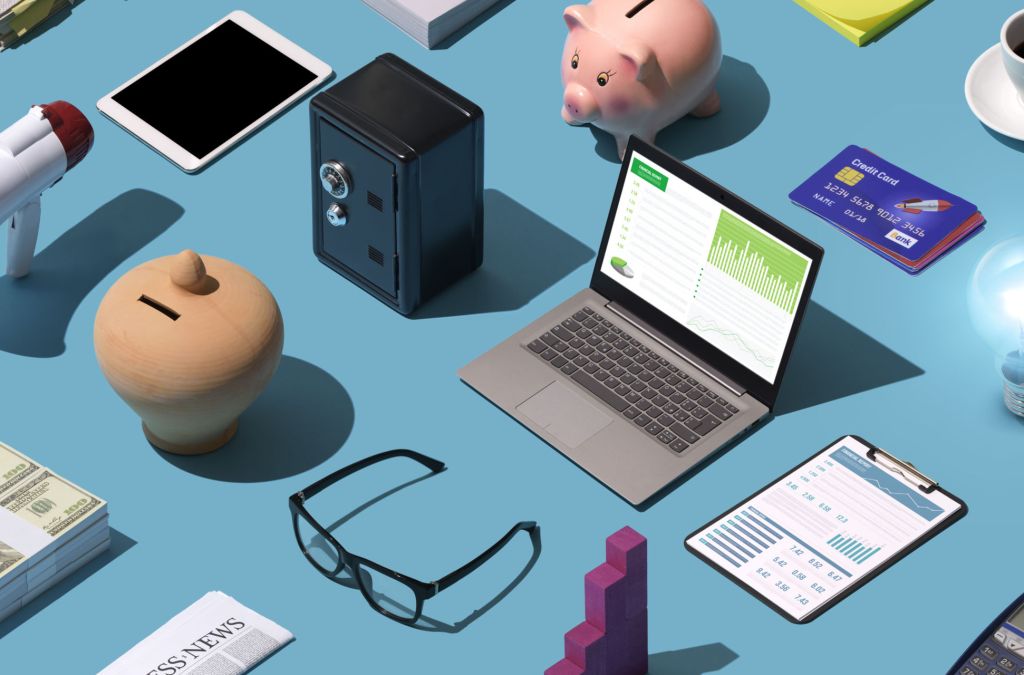 Business isometric desktop with laptop, lit bulb and assorted financial items